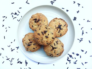 sweet and crunchy chocolate cookies or dry chocolate cake on white plate with white background.