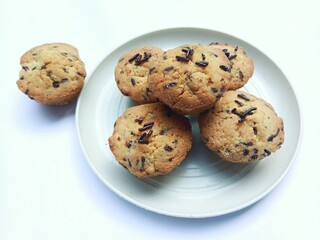 sweet and crunchy chocolate cookies or dry chocolate cake on white plate with white background.