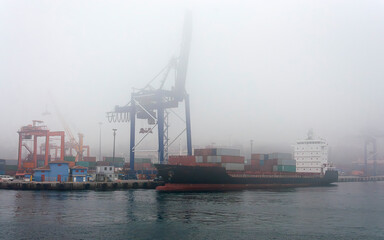 a ship loading in the port in foggy weather