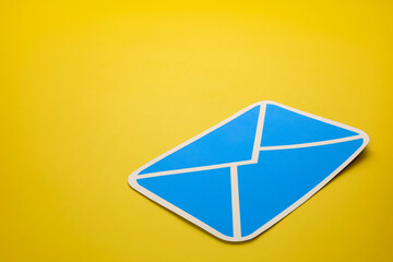 Paper letter on yellow background, with copy space. Business concepts of online contact channels, electronic mail inbox notifications, and sending and receiving documents using online networks.