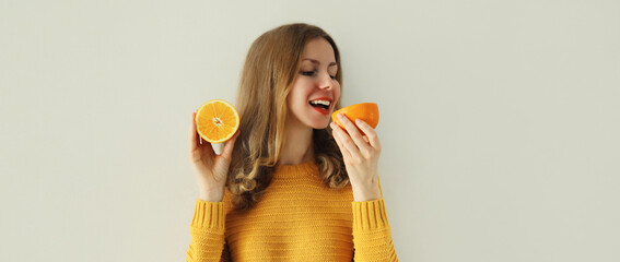 Nutrition, diet vegetarian concept. Happy healthy cheerful young woman with slices of orange fruits