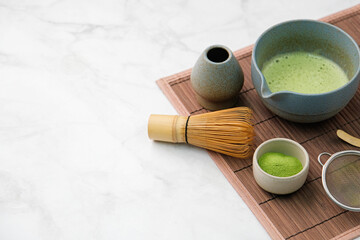 Traditional matcha kit, Bamboo whisk and beverage on bamboo mat in the kitchen