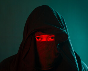 Male figure fully covered with red and green ambient lighting on black background, mysterious...