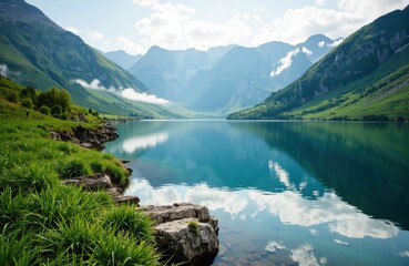 Naklejka premium Serene mountain lake surrounded by lush green hills and towering peaks