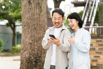 スマートフォンで調べものをするミドル夫婦　ライフスタイルイメージ