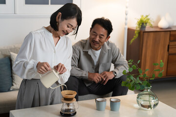 ミドル男性さんにコーヒーを淹れるミドル女性　ライフスタイルイメージ