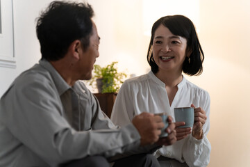 マグカップで飲み物を飲むミドル夫婦　ライフスタイルイメージ
