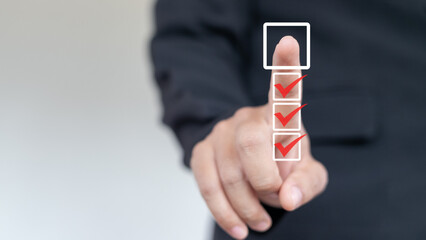 Businessman touching digital checklist with three completed tasks and one pending, representing...