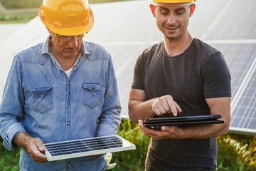 Engineers working at solar panels factory outdoor - Photovoltaic, renewable green energy and...