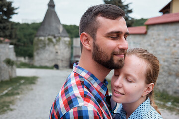 Happy Couple Embracing Outdoors on a Sunny Day in a Traditional Village