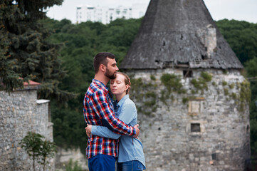 Couple Sharing an Embrace by a Rustic Stone Tower and Nature