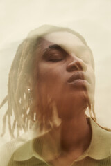 Young adult Black man closing eyes with head slightly tilted, wearing earring, medium length...