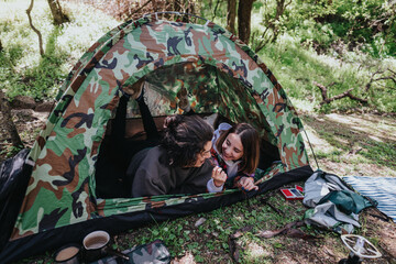 A happy young couple spending quality time together outdoors, relaxing inside a...