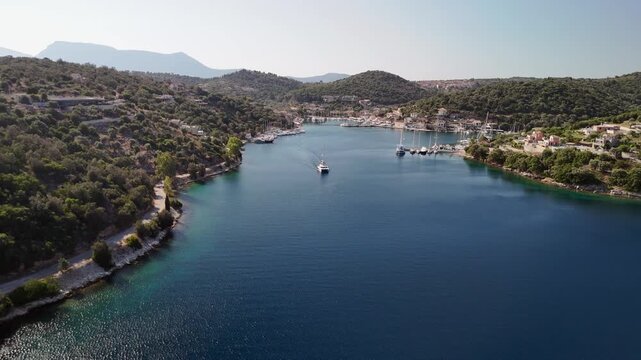 Low aerial flight into ocean inlet approaching sunny Vathy, Greece