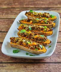 baked sweet potatoes stuffed with chorizo sausage, cheddar cheese, chipotle sauce, and green onions