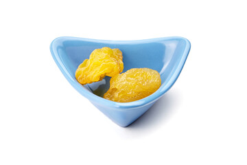 Dried dehydrated pear fruits displayed in a blue triangular bowl, showcasing their vibrant yellow color and unique texture, perfect for healthy snacking or culinary use