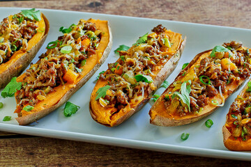baked sweet potatoes stuffed with chorizo sausage, cheddar cheese, chipotle sauce, and green onions