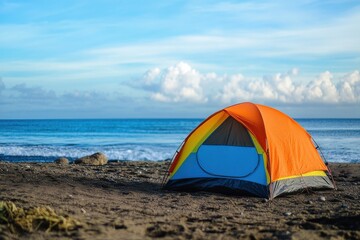 Bright orange tent on sandy beach with clear blue ocean and fluffy clouds on a sunny day
