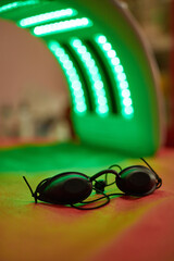 Safety glasses on the background of an LED lamp.