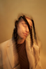 Portrait of young adult Black woman with long braids tilting head and closing eyes, motion blur...