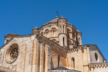 Colegiata de Santa Maria la Mayor de Toro stands majestically against a clear blue sky in Zamora,...
