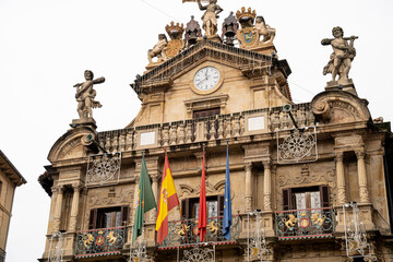 Historic city hall of Pamplona adorned with symbols and flags in Navarra, Spain on a cloudy day