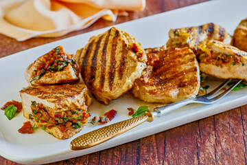 grilled pork chops stuffed with gouda cheese, bacon, spinach and sun dried tomatoes, with serving fork