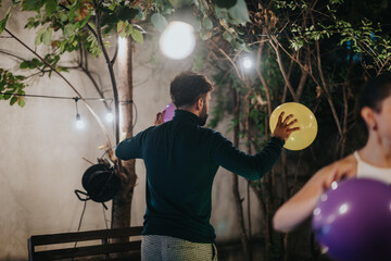 A festive gathering outdoors featuring balloons, string lights, and social interaction among...