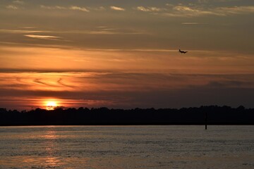 sunset on the river with airplane silhouette 