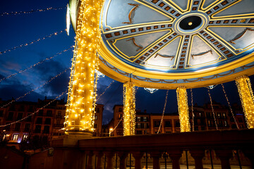 Illuminated gazebo at Plaza del Castillo in Pamplona during the evening with vibrant lights and...