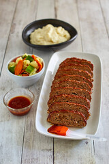 glazed meatloaf and mashed potatoes served with steamed vegetables