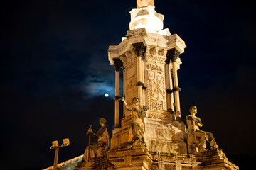 Monumento a los Fueros illuminated at night in Pamplona Navarra Spain under a full moon