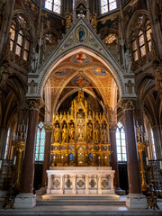 Obraz premium Golden altar and ornate architecture of Votivkirche church interior in Vienna, Austria.
