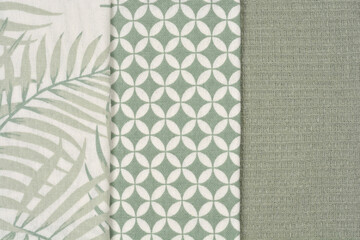 A trio of fabric swatches, featuring a palm leaf pattern, a geometric design, and a solid texture,...