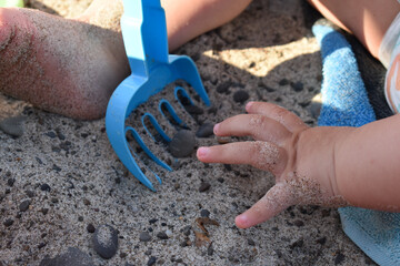Little kid sitting on the towel and playing with plastic toys. Little girl playing with plastic...