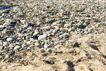 Natural background. Stone texture. Abstract background with pebbles and sand. Spiaggia Torre Conca: beach near Cefalu, Sicily. Summer and holidays. Summer beach in Italy.