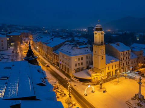 Aerial view of a snow-covered N&Atilde;&iexcl;mestie SNP square with its iconic clock tower illuminated against the dark winter sky, Bansk&Atilde;&iexcl; Bystrica, Banskobystrick&Atilde;&frac12; kraj, Slovakia.