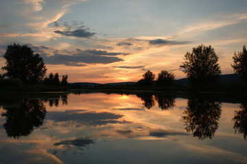 Fototapeta premium breathtaking summer sunset captures essence of warm evening where golden sunlight streams through fluffy clouds