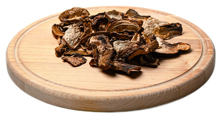 Dried mixed wild forest fungi mushrooms on a round wooden cutting board isolated on transparent...