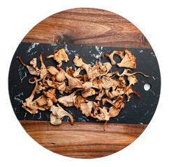 Dried wild forest mushrooms mix with chanterelles and porcini on black and wooden cutting board,...
