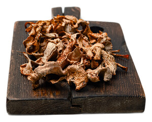 Organic dried wild forest mushrooms mix with chanterelles and porcini on rustic wooden board isolated on transparent background