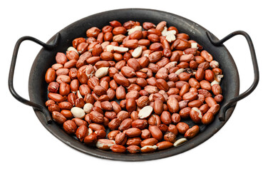 Raw unsalted redskinned peanuts with shells and skins in a black cast iron skillet, closeup of...