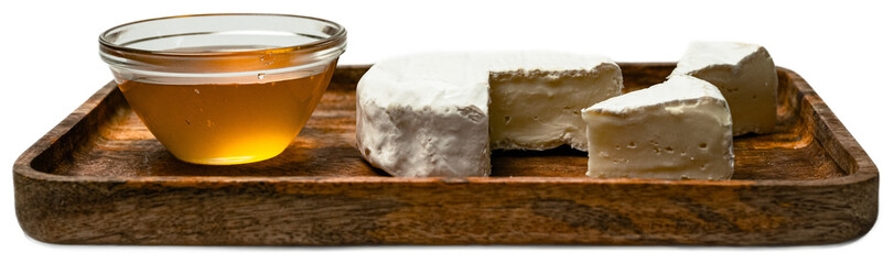 Creamy camembert cheese wheel with white mold, sliced for serving on wooden tray, accompanied by honey, highlighted by soft textures and elegant presentation on a transparent background
