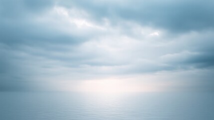 Fototapeta premium Serene seascape with calm water reflecting soft blue hues of overcast sky, creating a tranquil atmosphere with gentle waves and distant horizon, evoking peace and serenity