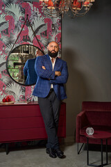 A stylish bearded man in a business suit in an interior