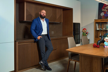 A stylish bearded man in a business suit in an interior