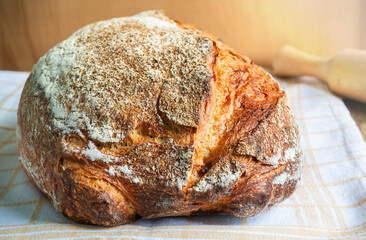Freshly baked artisan bread resting on a cloth in a cozy kitchen setting during the afternoon