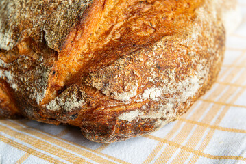 Freshly baked artisan bread resting on a cloth in a cozy kitchen setting during the afternoon