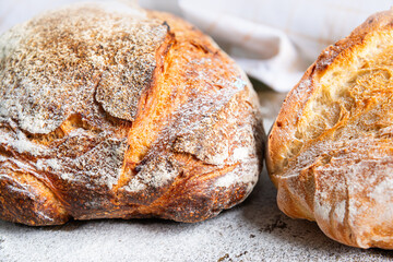 Freshly baked artisan bread loaves on a rustic countertop with flour dusting in a cozy kitchen