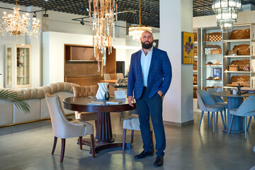 A stylish bearded man in a business suit in an interior